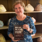 Ginger with her book in front of a fish